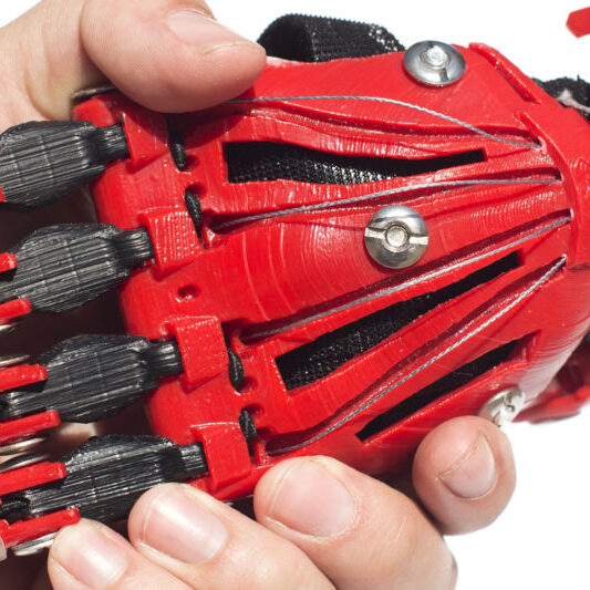 Robotic hand and human hand clasped in a handshake