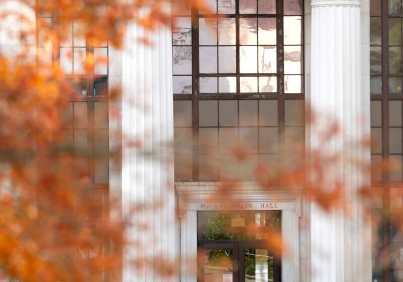 Berkeley's white, neoclassical Engineering building with red leaves in the foreground